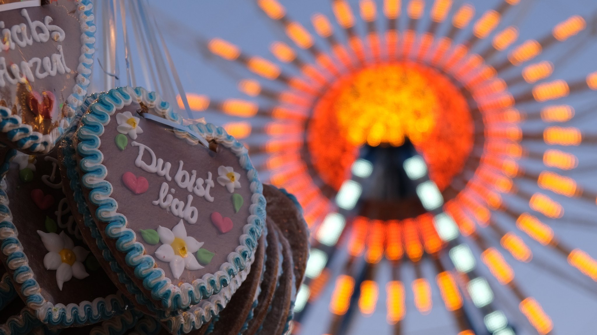 Blick auf Lebkuchenherzen und das Riesenrad auf der Wiesn 2022.