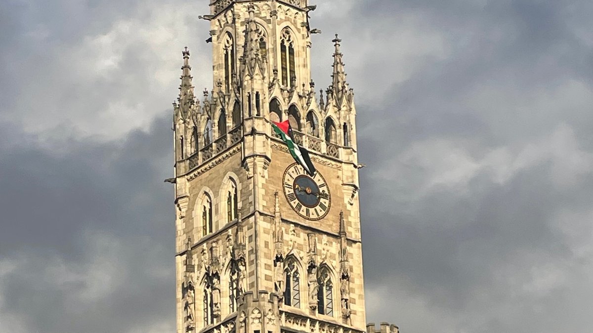 Eine palästinensische Flagge hängt aus dem Turm des Münchner Rathauses.