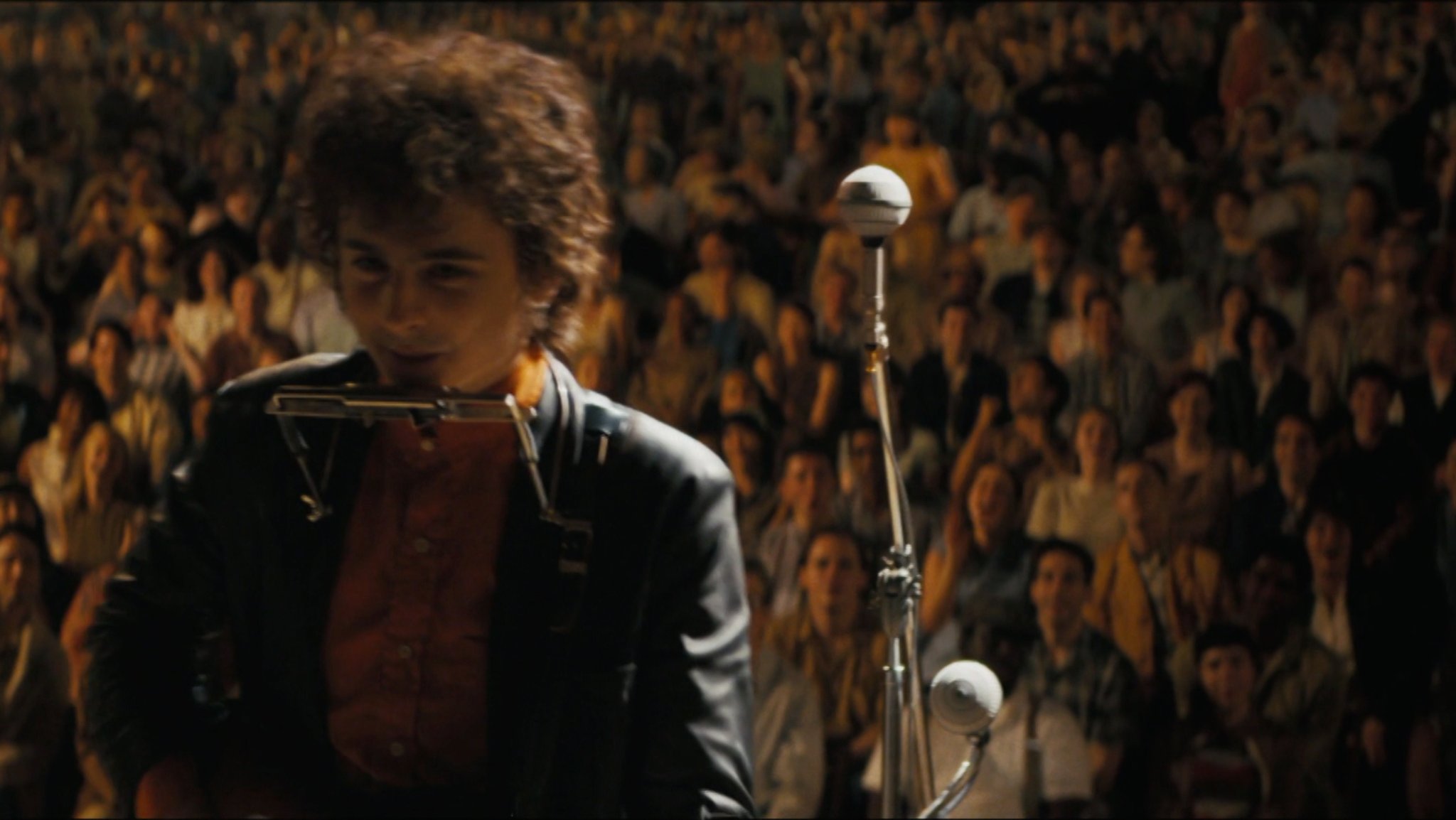 Szene aus dem Spielfilm "Like A Complete Unknown" mit Timothée Chalamet bei einem Auftritt in der Rolle des Bob Dylan.