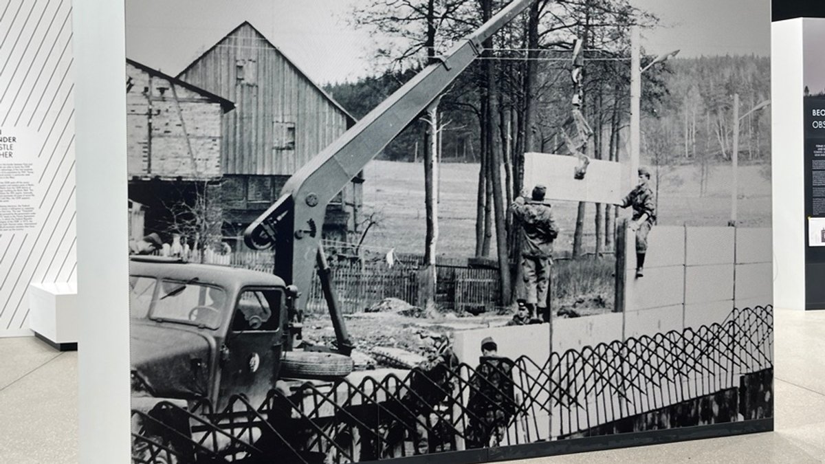 Foto vom Mauerbau in Mödlareuth zu sehen im neuen Museum- im Hintergrund Teile eines Bauernhofs
