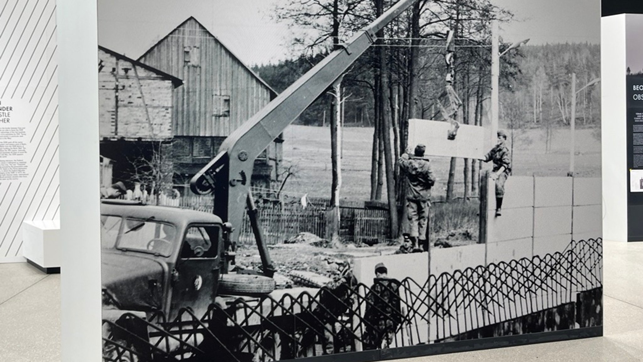 Foto vom Mauerbau in Mödlareuth zu sehen im neuen Museum- im Hintergrund Teile eines Bauernhofs