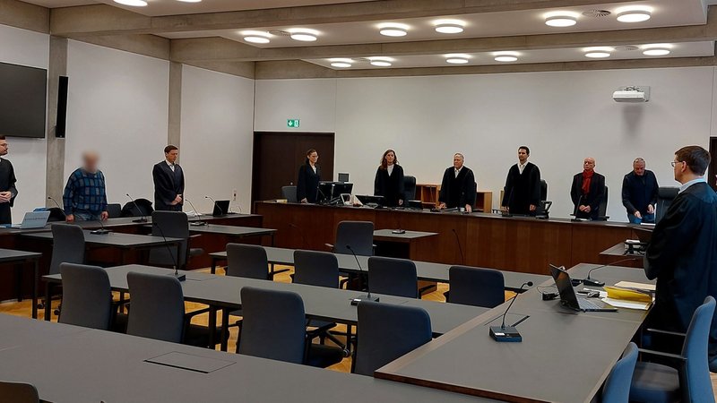 Männer und Frauen in einem Gerichtssaal.