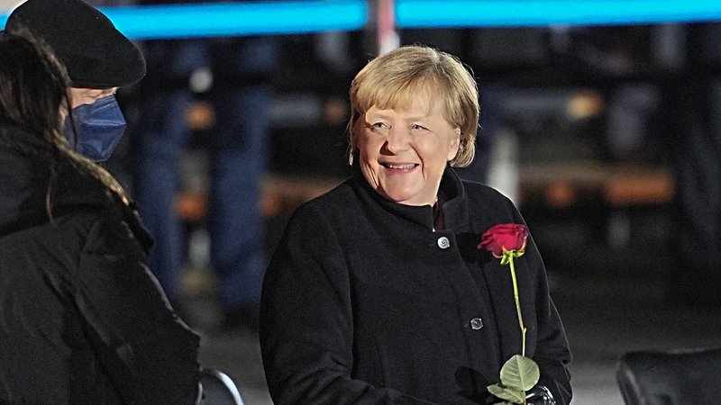 02.12.2021, Berlin: Bundeskanzlerin Angela Merkel (CDU) lacht nach ihrer Verabschiedung durch die Bundeswehr mit einer Rosen in der Hand neben ihrem Mann, Joachim Sauer. Mit einem Großen Zapfenstreich wird Kanzlerin Merkel gegen Ende ihrer Regierungszeit nach 16 Jahren im Bendlerblock verabschiedet | Bild: dpa-Bildfunk/Michael Kappeler 02.12.2021, Berlin: Bundeskanzlerin Angela Merkel (CDU) lacht nach ihrer Verabschiedung durch die Bundeswehr mit einer Rosen in der Hand neben ihrem Mann, Joachim Sauer. Mit einem Großen Zapfenstreich wird Kanzlerin Merkel gegen Ende ihrer Regierungszeit nach 16 Jahren im Bendlerblock verabschiedet