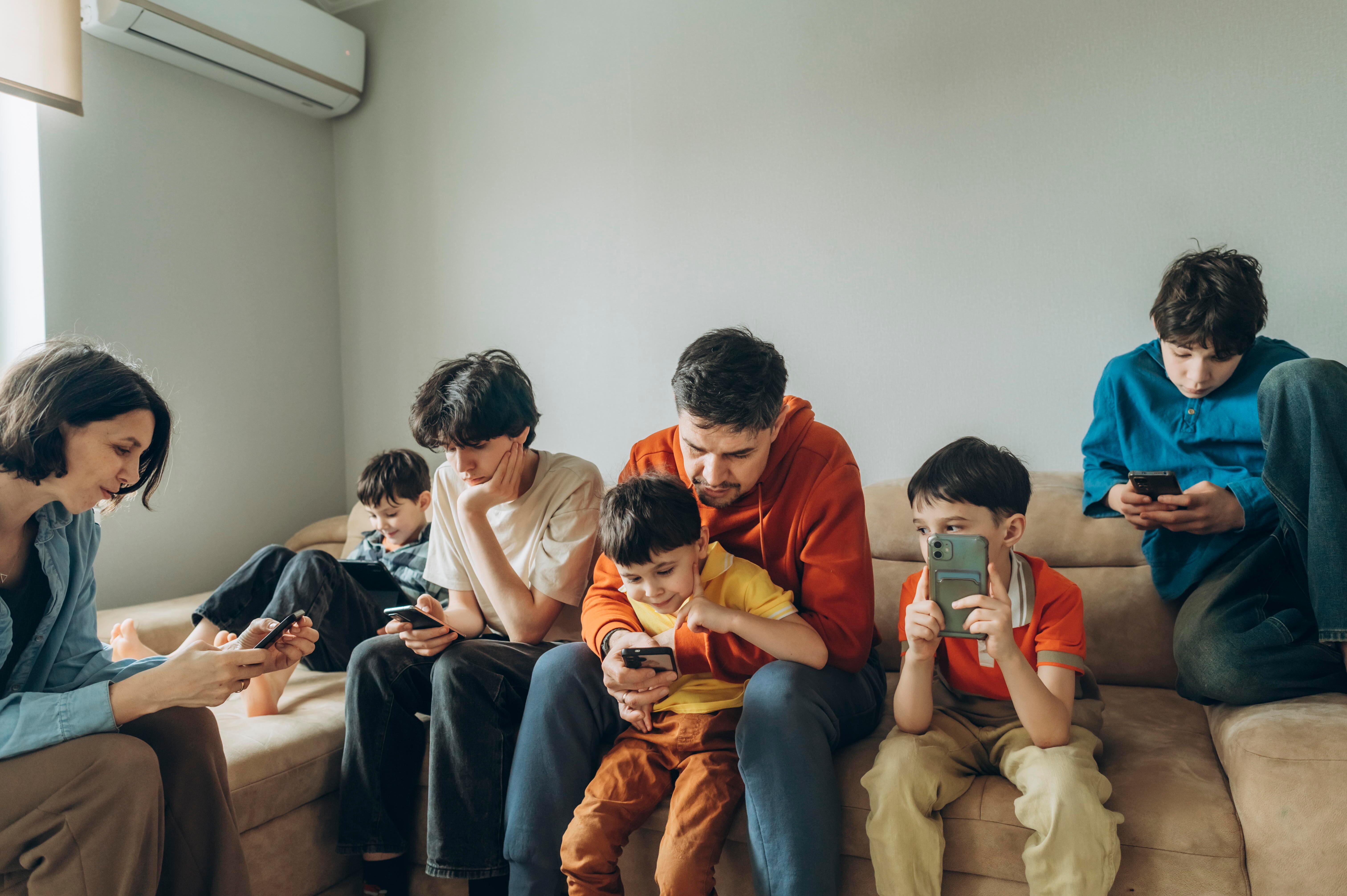 Familie mit Handys auf dem Sofa