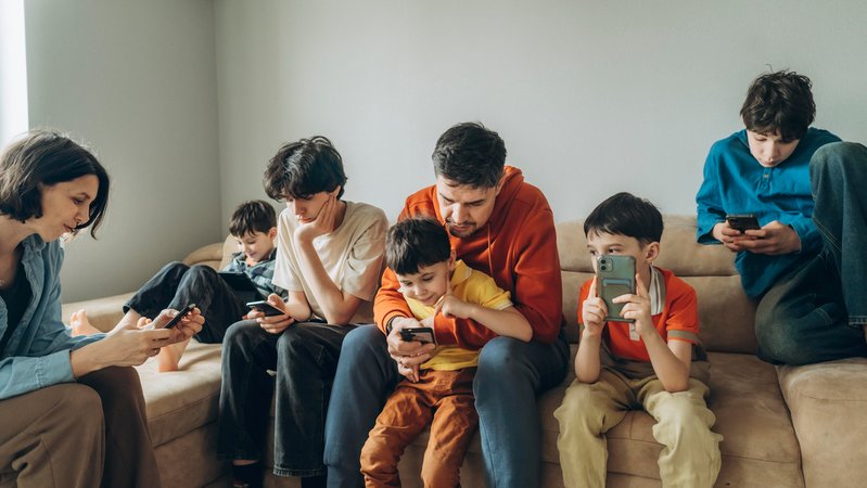 Familie mit Handys auf dem Sofa | Bild: picture alliance / Westend61 | Anastasiya Amraeva Familie mit Handys auf dem Sofa