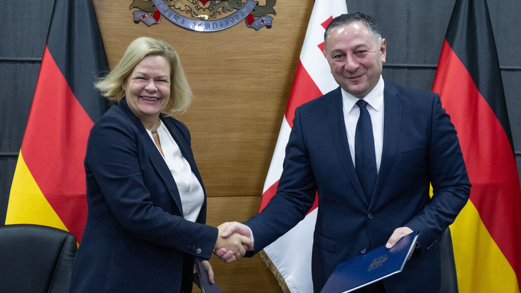 19.12.2023, Georgien, Tiflis: Bundesinnenministerin Nancy Faeser (SPD, l) und der georgische Innenminister Vakhtang Gomelauri untereichnen ein gemeinsames Migrationsabkommen. Foto: Boris Roessler/dpa +++ dpa-Bildfunk +++