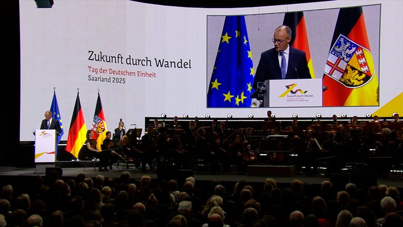 Bundeskanzler Friedrich Merz (CDU) spricht bei den zentralen Feierlichkeiten zum Tag der Deutschen Einheit in der Kongresshalle in Saarbrücken. | Bild: BR Bundeskanzler Friedrich Merz (CDU) spricht bei den zentralen Feierlichkeiten zum Tag der Deutschen Einheit in der Kongresshalle in Saarbrücken.