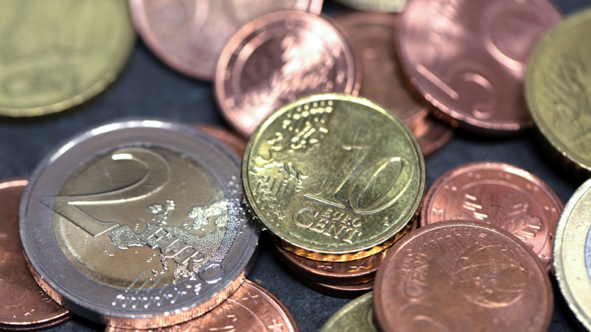 Eine Handvoll Euro- und Centmünzen auf einer dunklen Oberfläche (Symbol- und Archivbild)