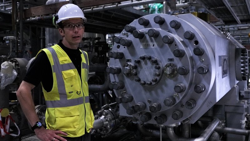MAN-Projektleiter Karl Böhle vor einem Kompressor der Wärmepumpe in Esbjerg