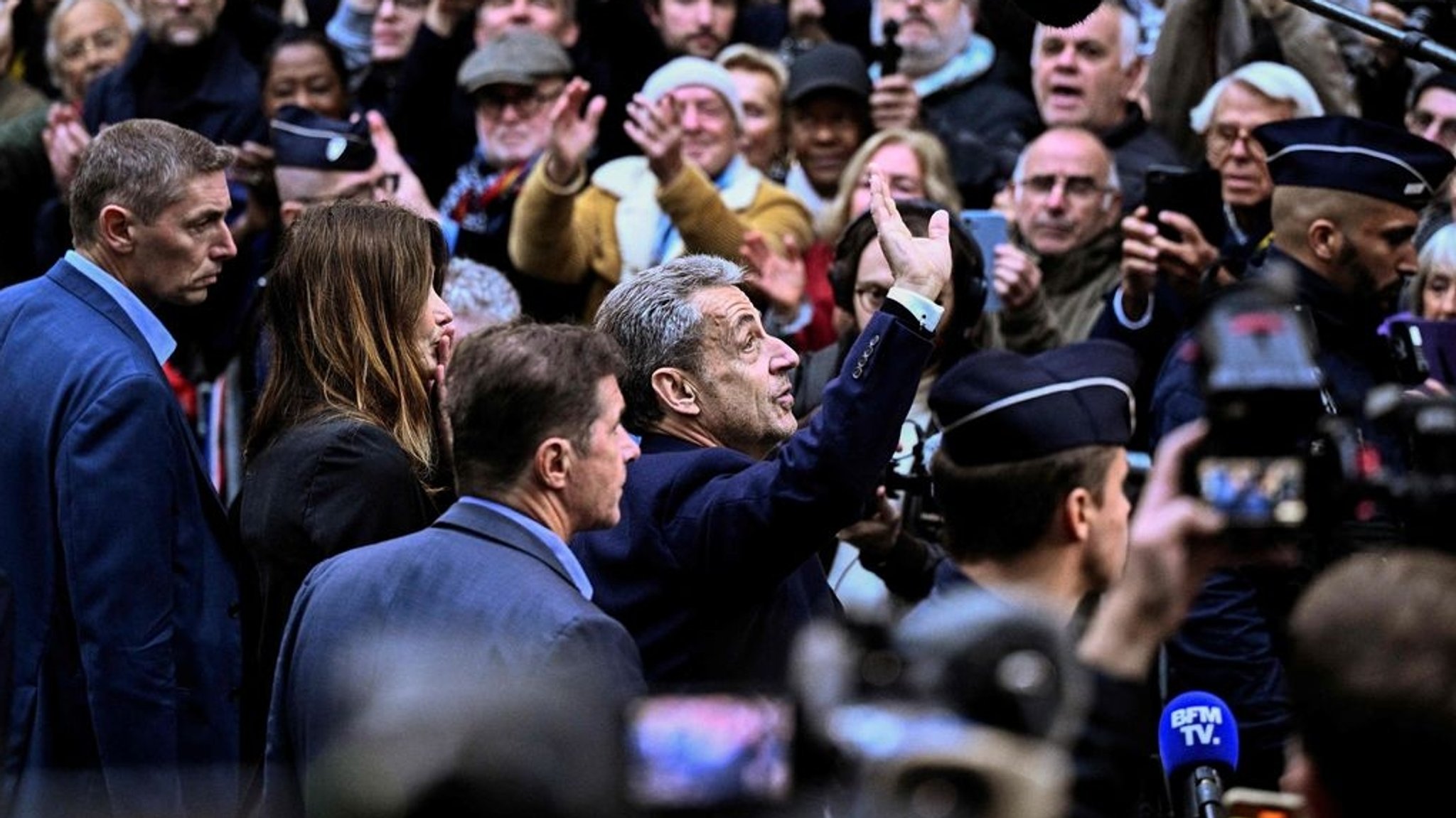 21.10.2025, Frankreich, Paris: Frankreichs ehemaliger Präsident Nicolas Sarkozy (M) winkt seinen Anhängern zu, als er seinen Wohnsitz verlässt, um sich im Gefängnis La Sante einzufinden, wo er zu einer fünfjährigen Haftstrafe verurteilt wurde. Der ehemalige französische Präsident Nicolas Sarkozy muss wegen einer kriminellen Verschwörung zur Finanzierung seines Wahlkampfes 2007 mit Geldern aus Libyen ins Gefängnis. Foto: Julien De Rosa/AFP/dpa +++ dpa-Bildfunk +++