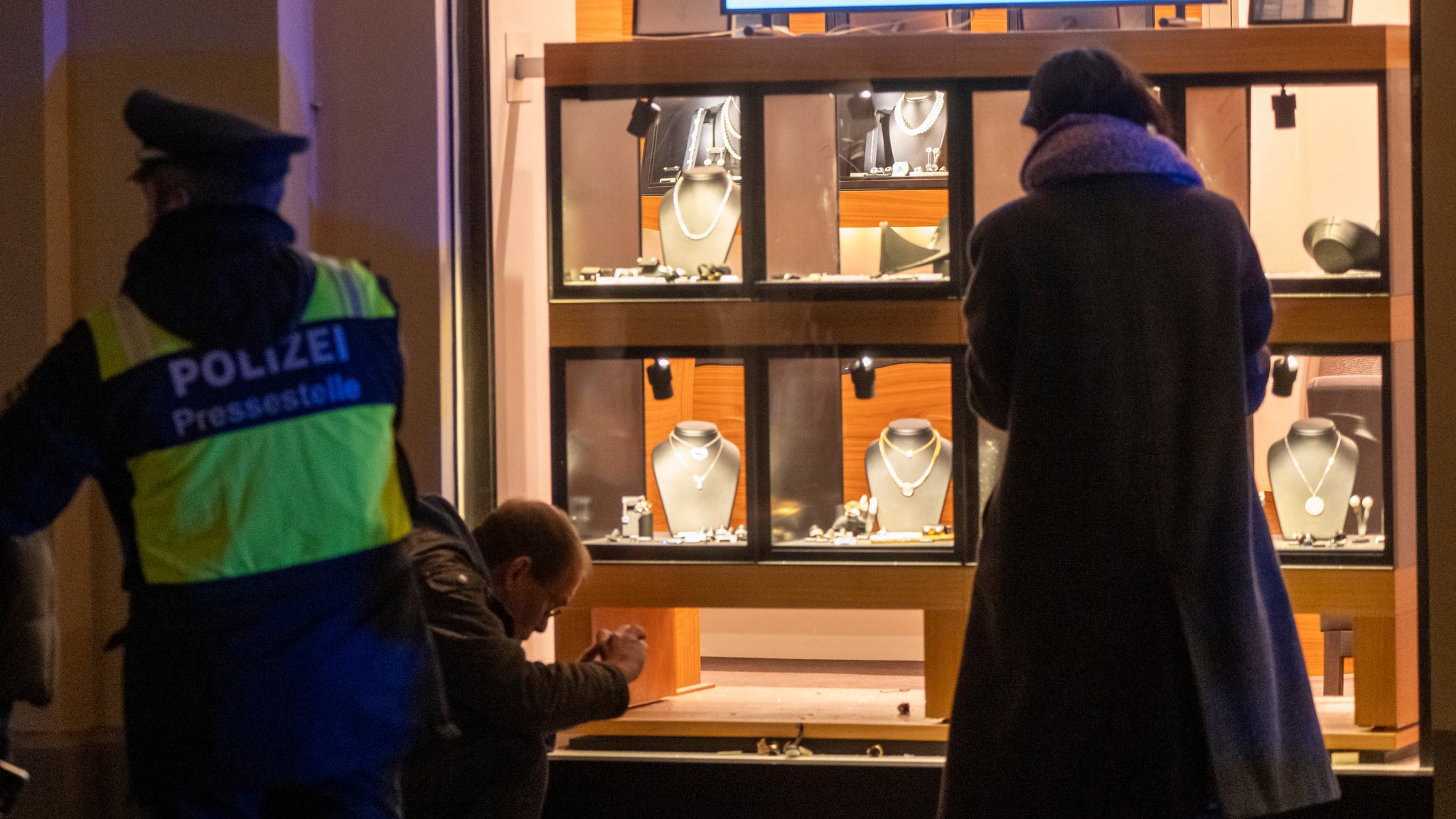 Polizisten stehen nach einem Überfall in einem Juweliergeschäft in der Innenstadt vor dem Laden.