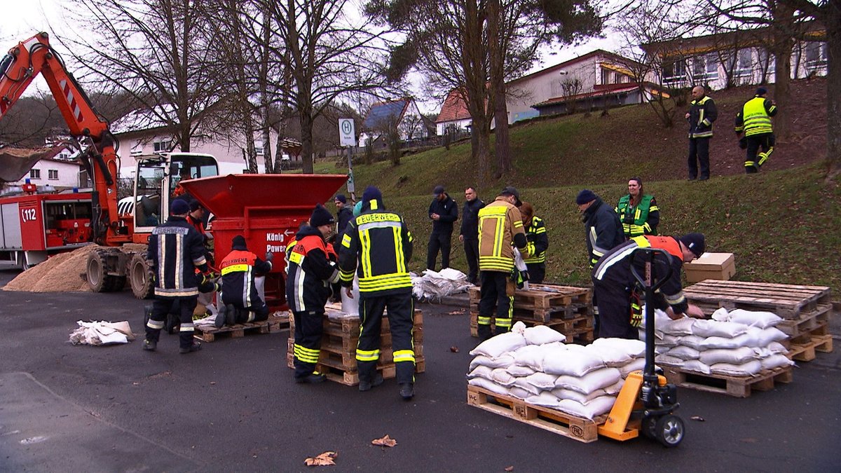 Feuerwehrleute befüllen in Gräfendorf Sandsäcke