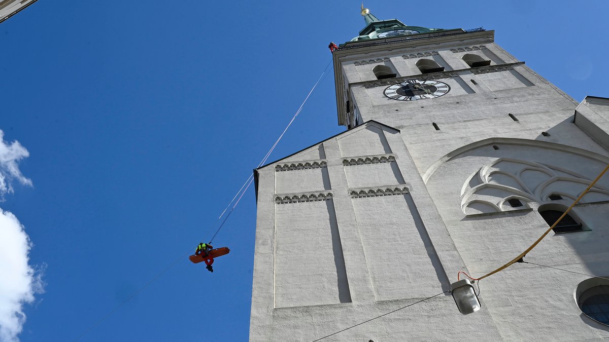 Alter Peter in München mit Blick auf den Turm von unten - in der Luft schwebt ein Feuerwehrmann mit Trage, die mit Seilen gesichert wird