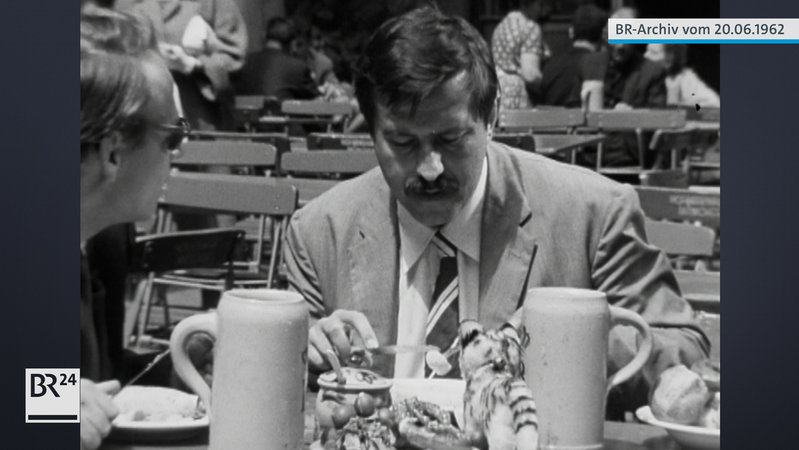 Günter Grass im Biergarten beim Essen von Wurst