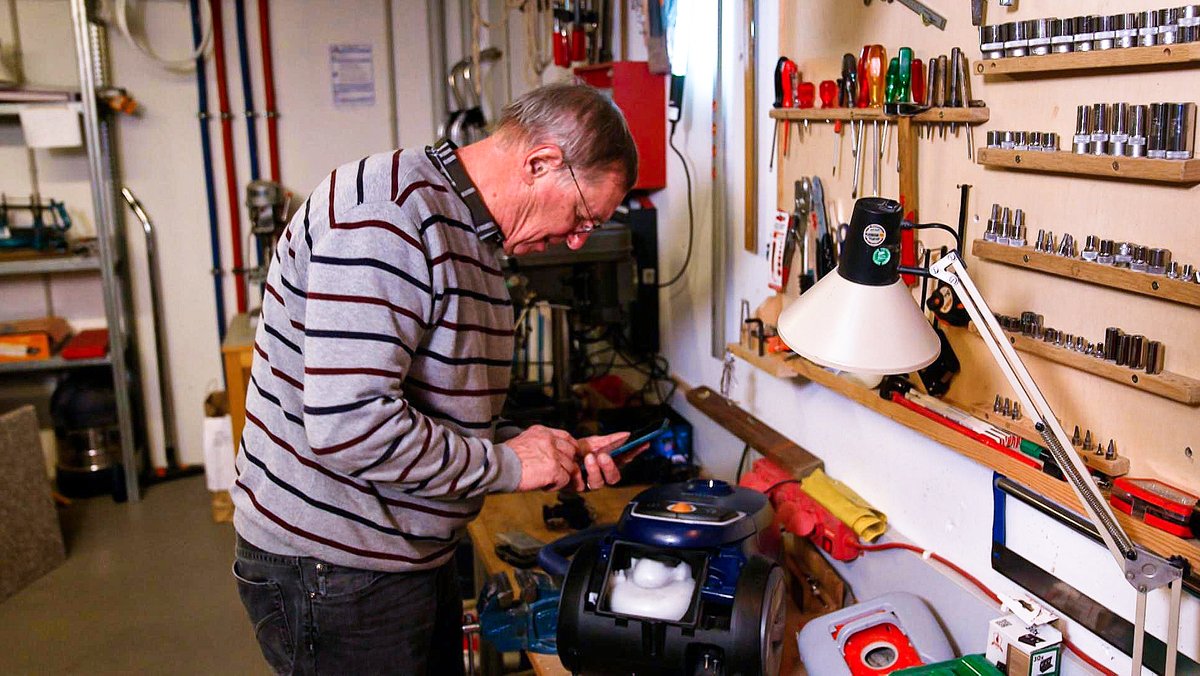 Ekkehard Dembek repariert einen Staubsauger in seiner privaten Werkstatt.
