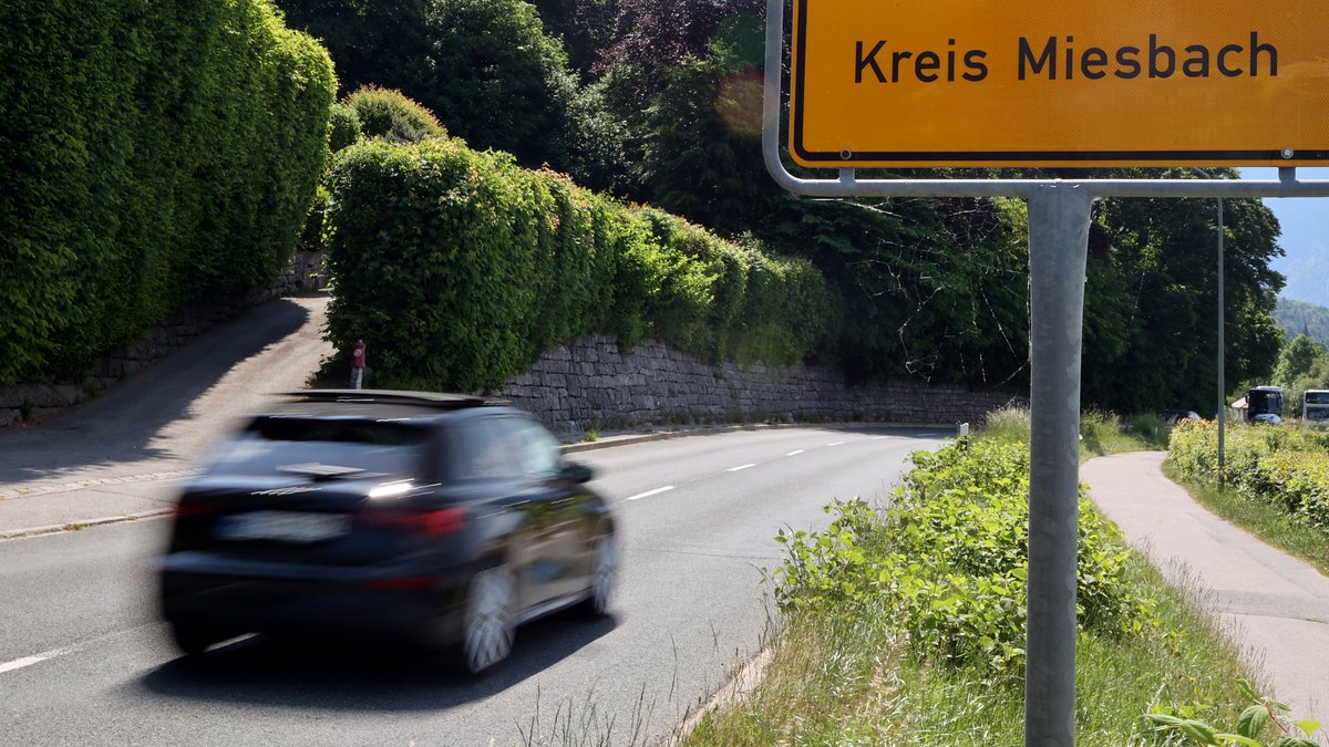 Ein Kleinwagen fährt an einem Ortschild im Landkreis Miesbach vorbei