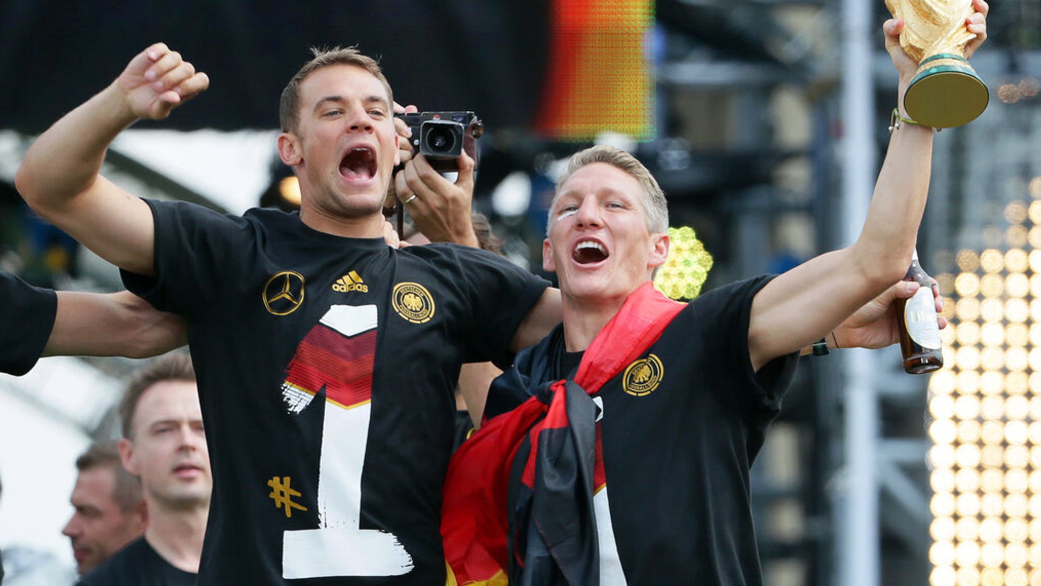 ARCHIV - 15.07.2014, Berlin: Manuel Neuer (l) und Bastian Schweinsteiger jubeln beim Empfang der Fußball-Nationalmannschaft mit dem WM-Pokal. Nach 1954, 1974 und 1990 ist Deutschland mit einem Sieg über Argentinien zum vierten Mal Weltmeister geworden. Deutschlands Rekordtorhüter Manuel Neuer beendet seine Karriere in der Fußball-Nationalmannschaft. Nach acht großen Turnieren als Nummer eins ist Schluss für den 38 Jahre alten Weltmeister von 2014. Foto: Michael Kappeler/dpa +++ dpa-Bildfunk +++