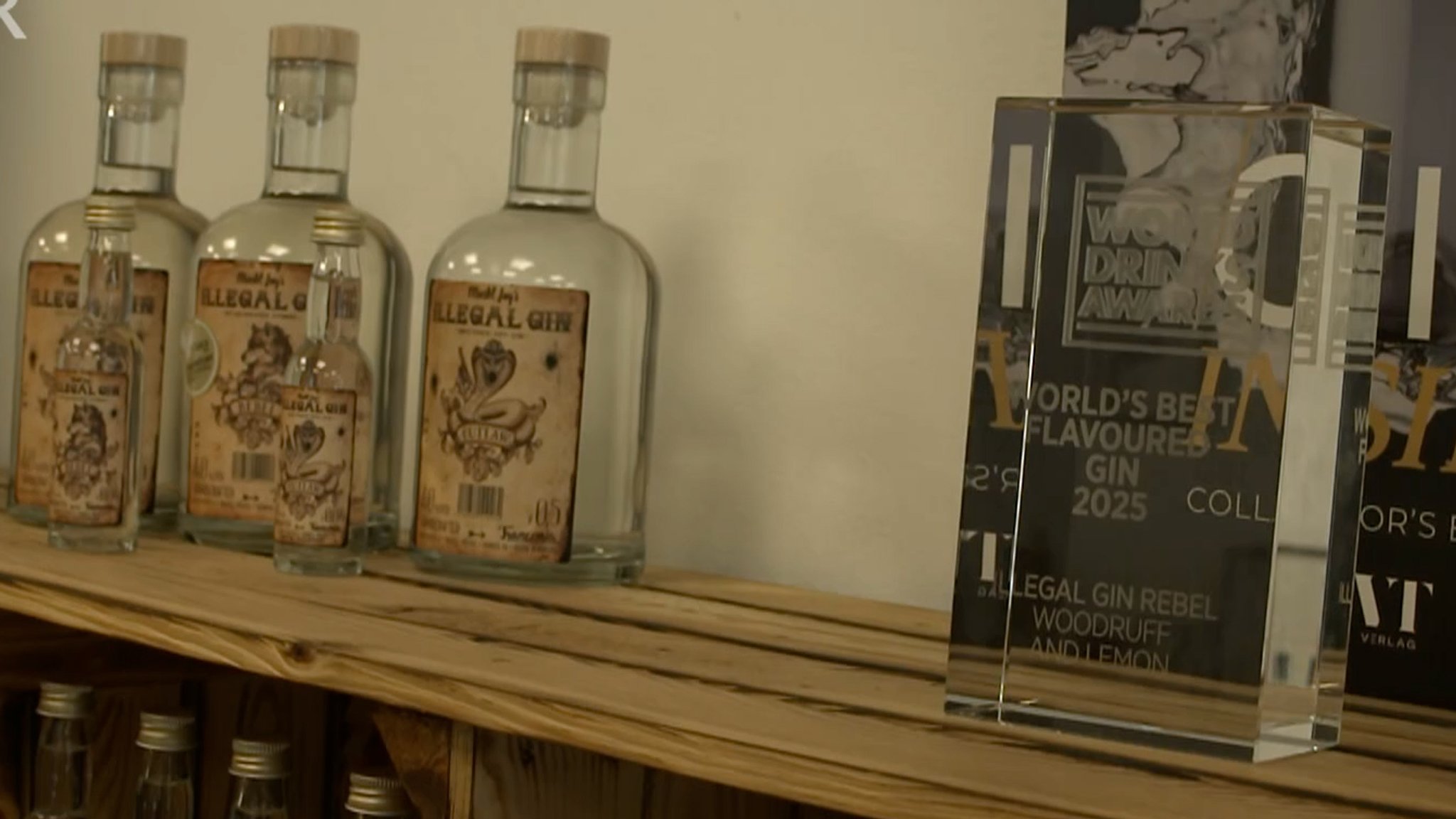 Gin-Flaschen auf einem Regal neben einer Auszeichnung.