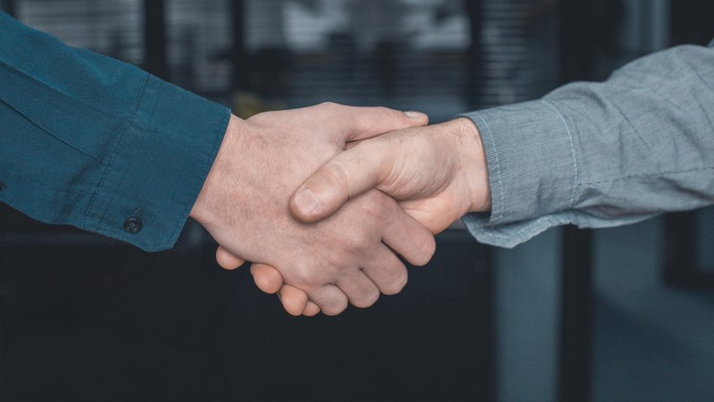 Handschlag zwischen zwei Männern (Symbolbild) | Bild: picture alliance / imageBROKER | Valeria Venezia Handschlag zwischen zwei Männern (Symbolbild)