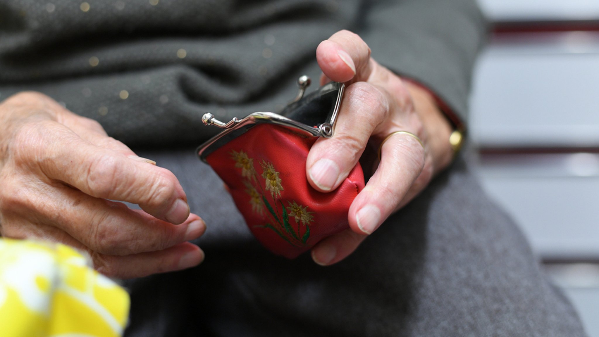 Alte Frau mit Geldbörse in der Hand