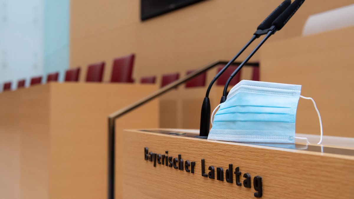 Ein Mund-Nasen-Schutz liegt auf dem Redner-Pult im Bayerischen Landtag.