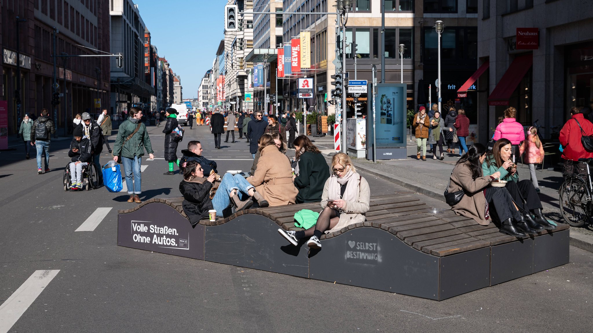 Fußgänger gehen im Berliner Bezirk Mitte über die autofreie Friedrichstraße