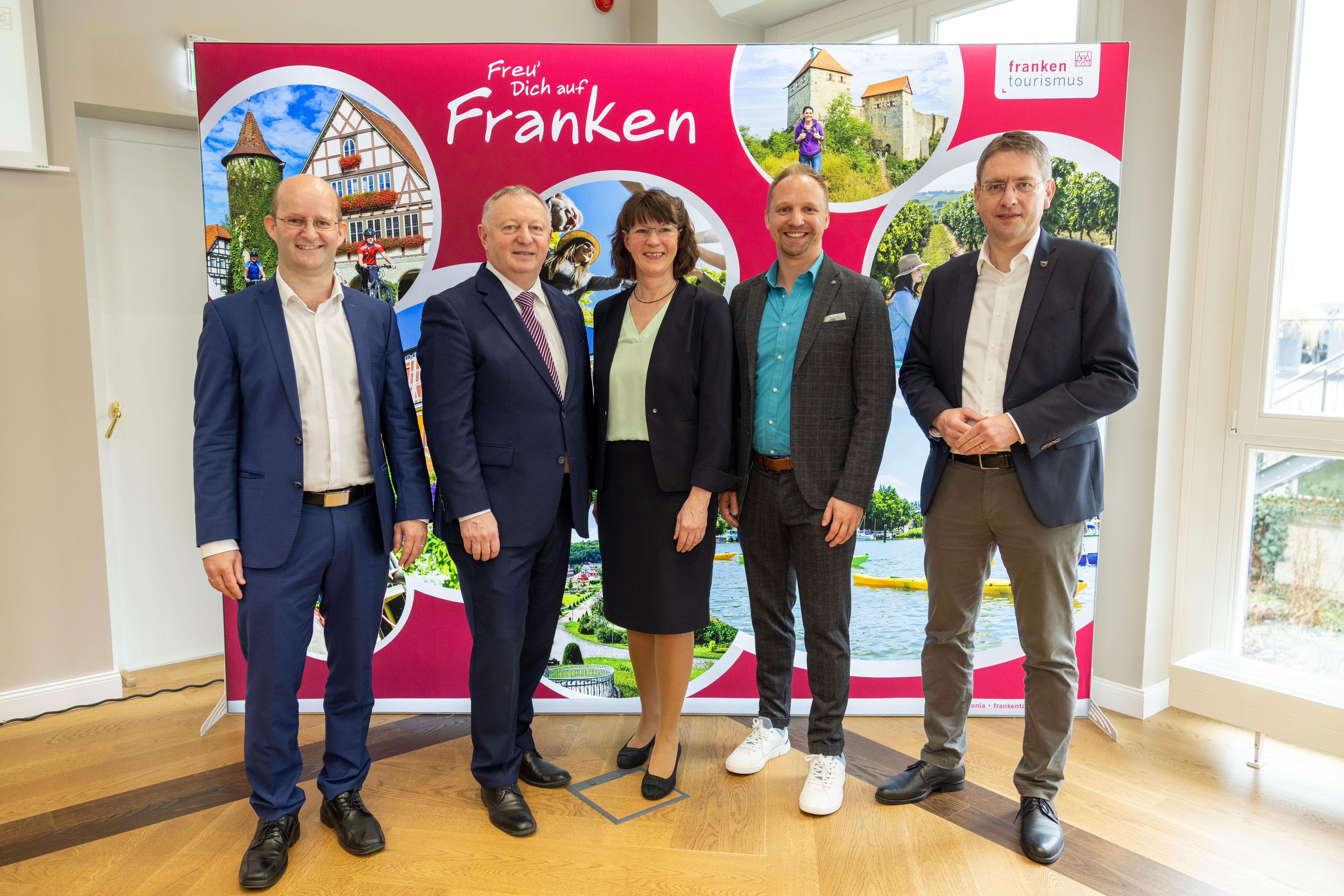 Tourismusverband Franken posiert vor Plakat