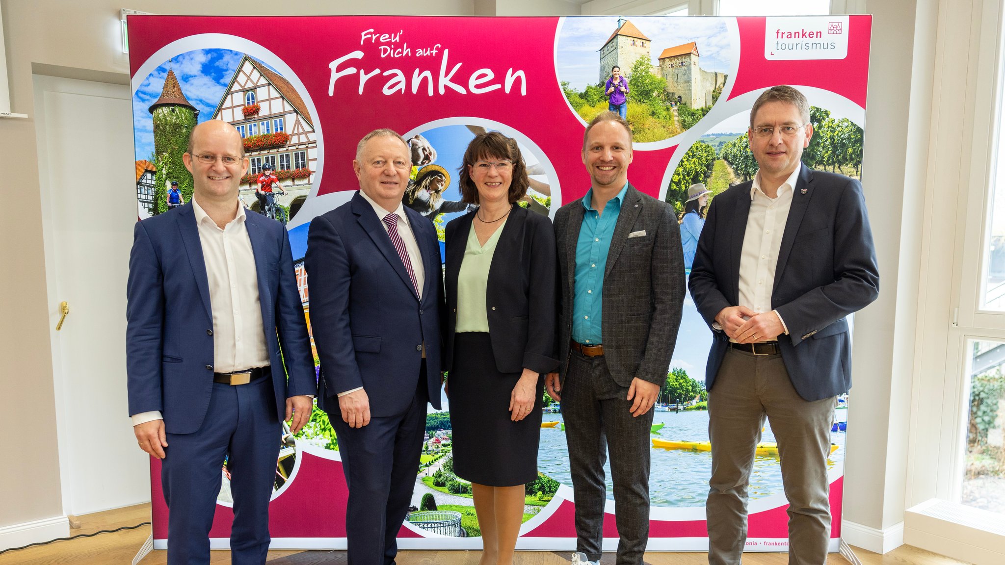 Tourismusverband Franken posiert vor Plakat