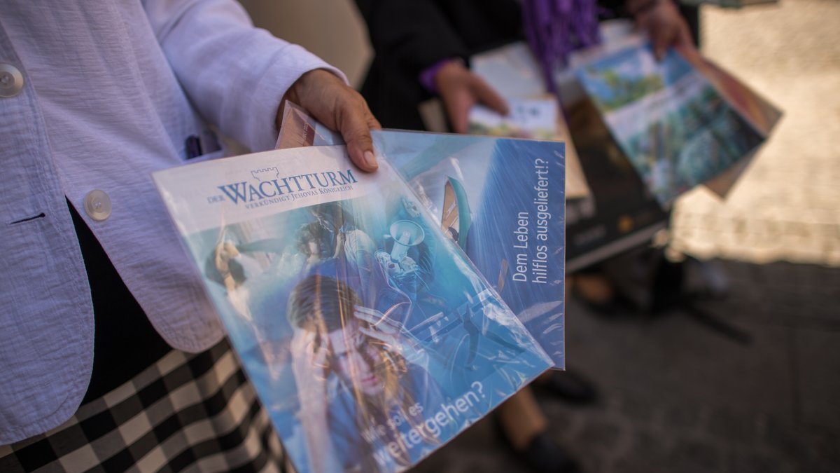 Archivbild: Mitglieder der Religionsgemeinschaft "Zeugen Jehovas" verteilen am 27.07.2015 ihre Hefte in München.