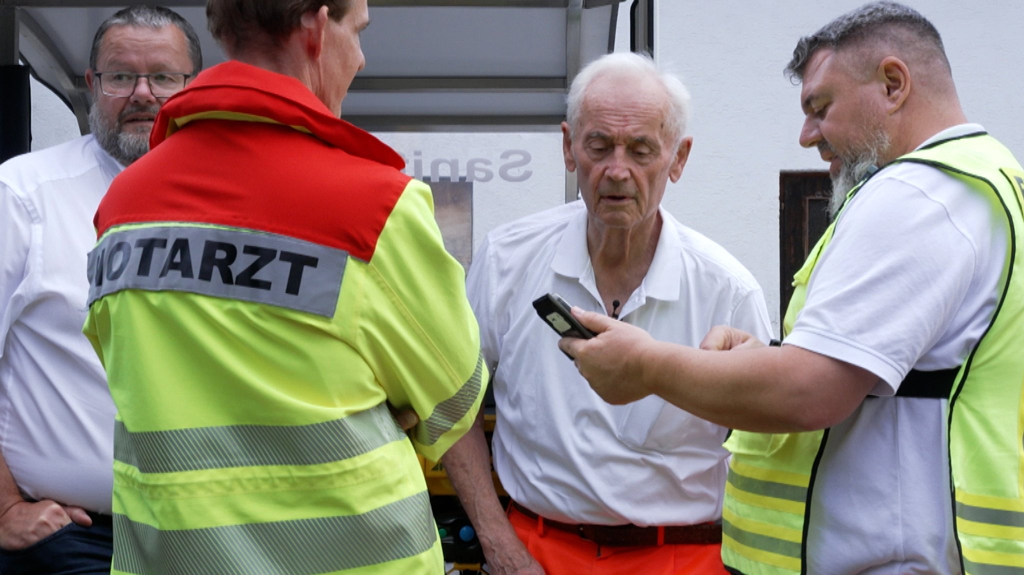 Der 80-jährige Notarzt Alfons Haßfurter auf der Sanitätswache mit Kollegen und Helfern