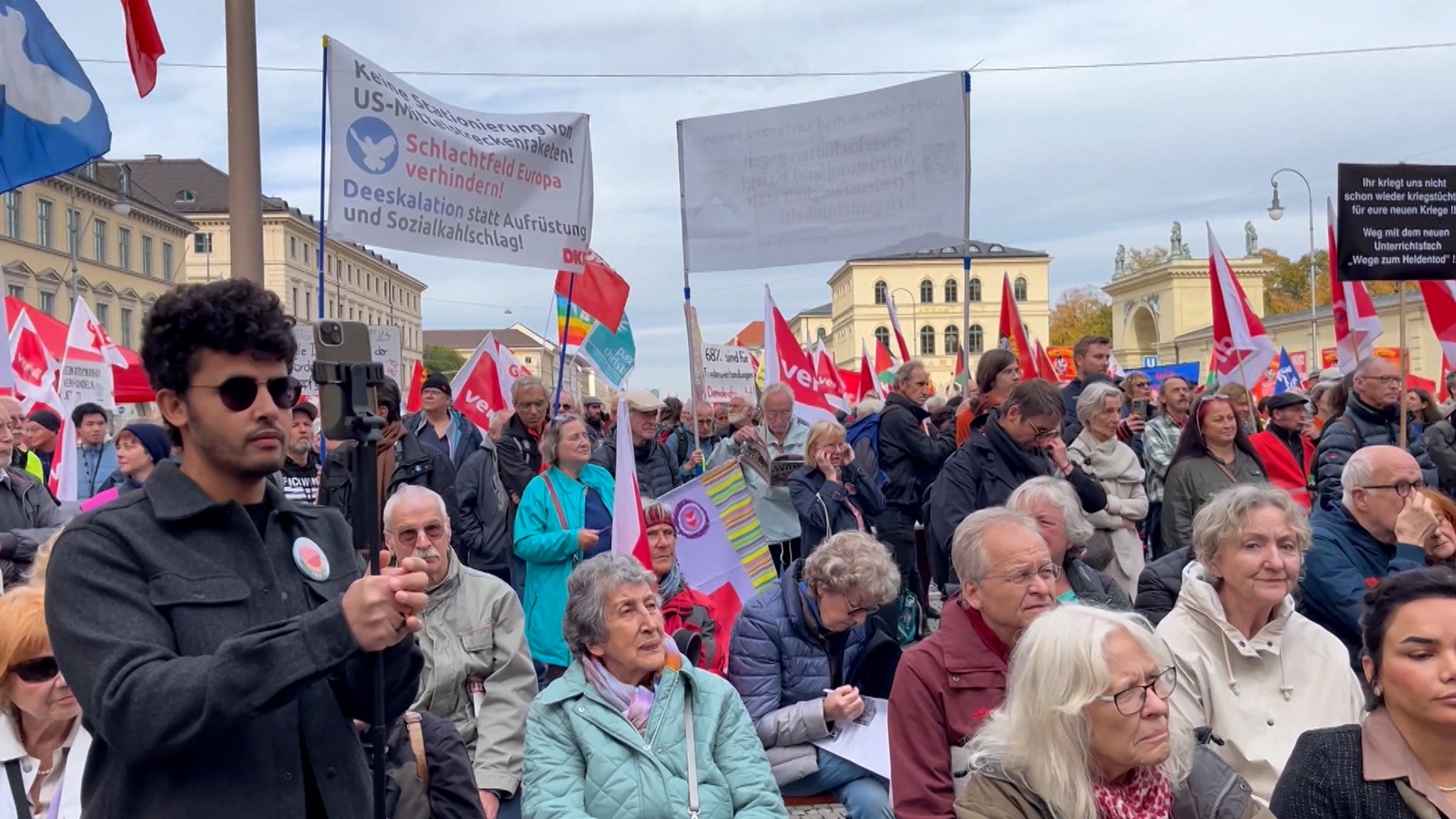 Demonstrierende auf dem Odeonsplatz in München mit Transparenten.