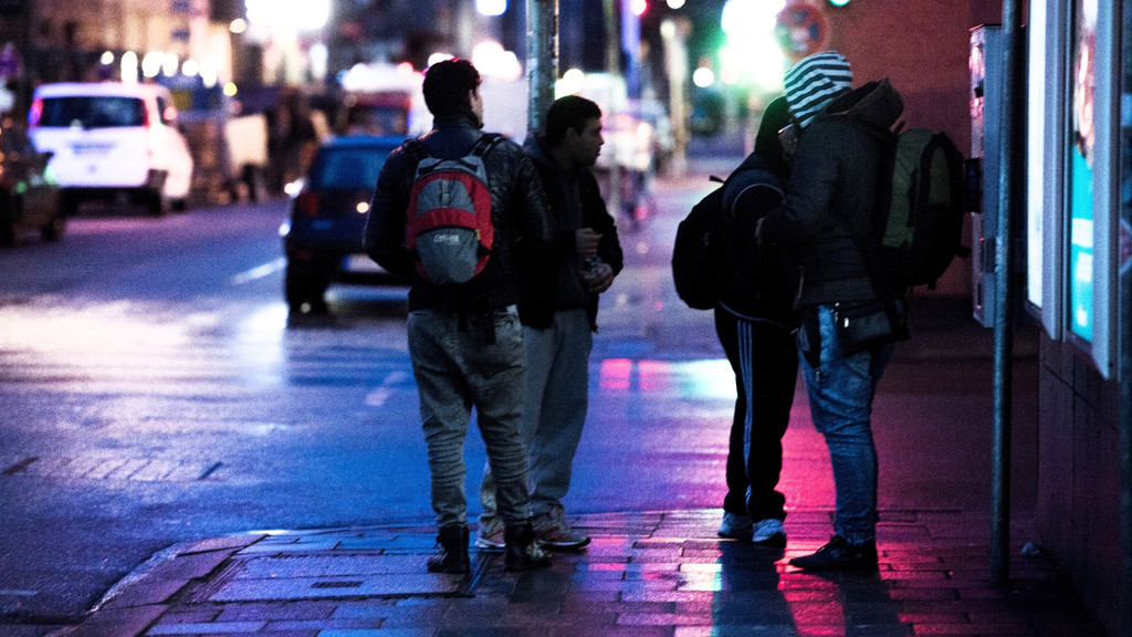 Tagelöhner stehen abends an einer Straßenecke