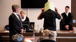 Der Angeklagte verbirgt seinen Kopf hinter einer Aktenmappe vor Gericht in Berlin. | Bild:dpa-Bildfunk/Fabian Sommer