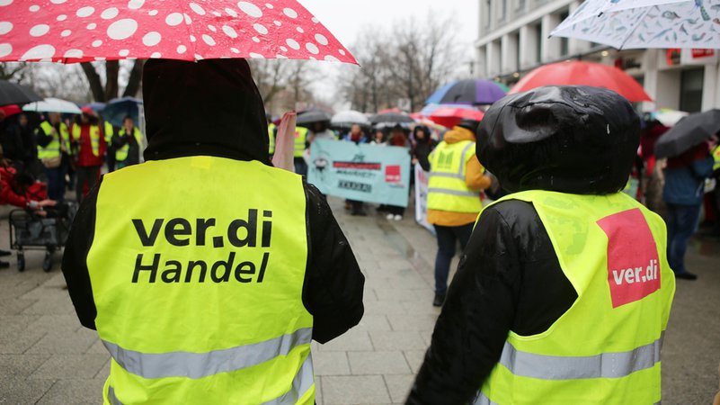 Teilnehmer einer Verdi-Kundgebung tragen gelbe Westen mit der ver.di Aufschrift. Im festgefahrenen Tarifstreit des Einzelhandels hatte die Gewerkschaft Verdi Beschäftigte bundesweit zu Warnstreiks aufgerufen. | Bild: dpa-Bildfunk/Stefan Rampfel Teilnehmer einer Verdi-Kundgebung tragen gelbe Westen mit der ver.di Aufschrift. Im festgefahrenen Tarifstreit des Einzelhandels hatte die Gewerkschaft Verdi Beschäftigte bundesweit zu Warnstreiks aufgerufen.