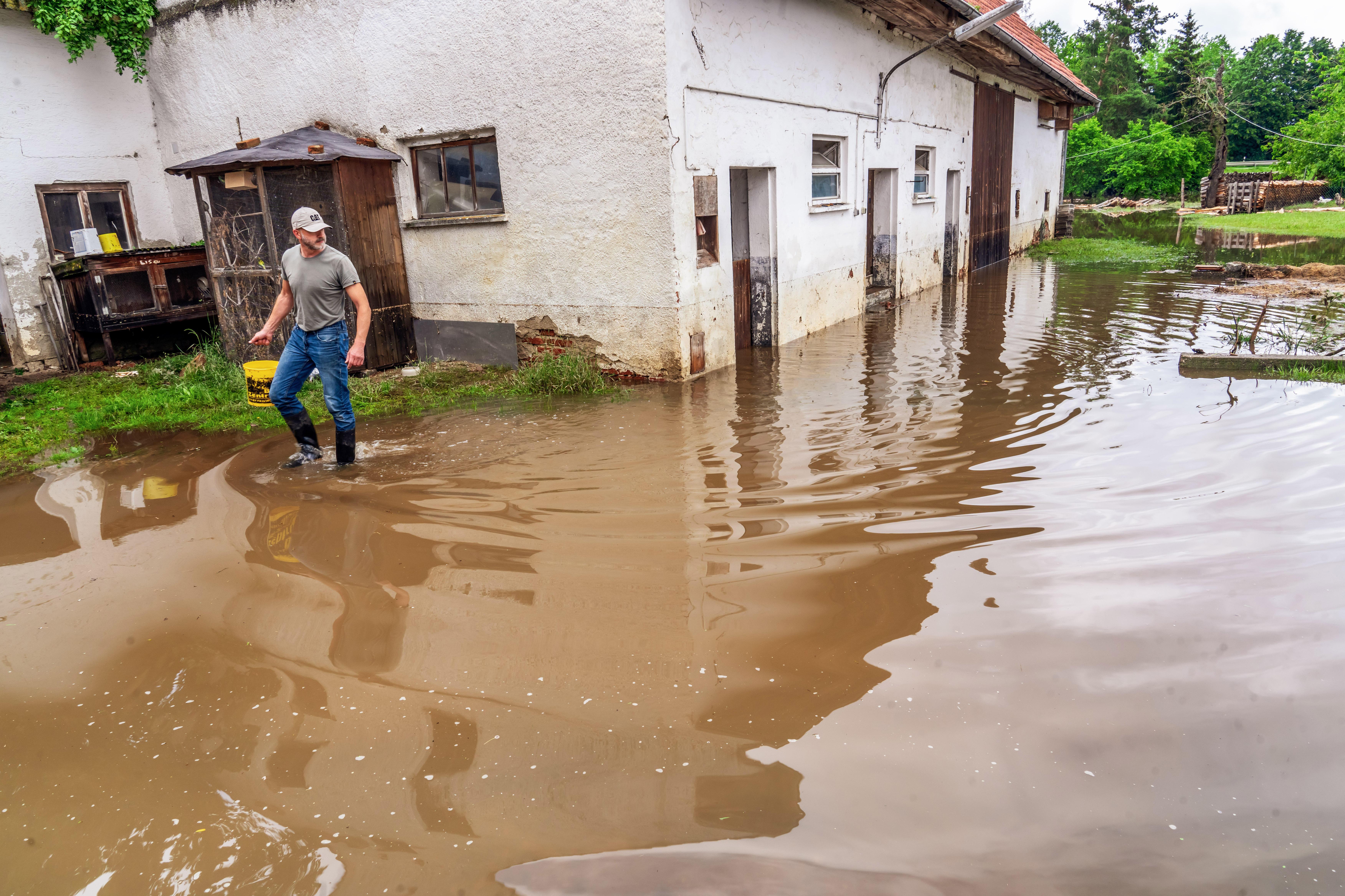 (Archivbild) Ein Bauer schaut sich die Lage auf seinem Bauernhof während der Hochwasser 2024 an, der Stall muss vielleicht abgerissen werden.