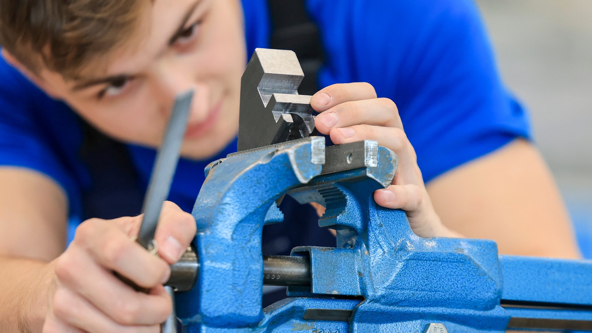 Junger Mann feilt an einem Bauteil | Bild: picture alliance/ Jan Woitas Junger Mann feilt an einem Bauteil