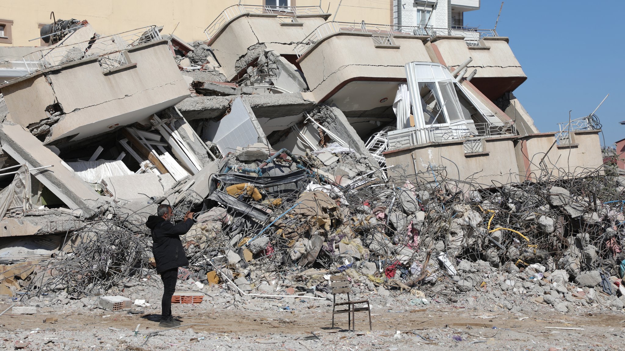 Ein Mann fotografiert zerstörte Gebäude in Islahiye nach den Erdbeben in der Türkei und Syrien. 