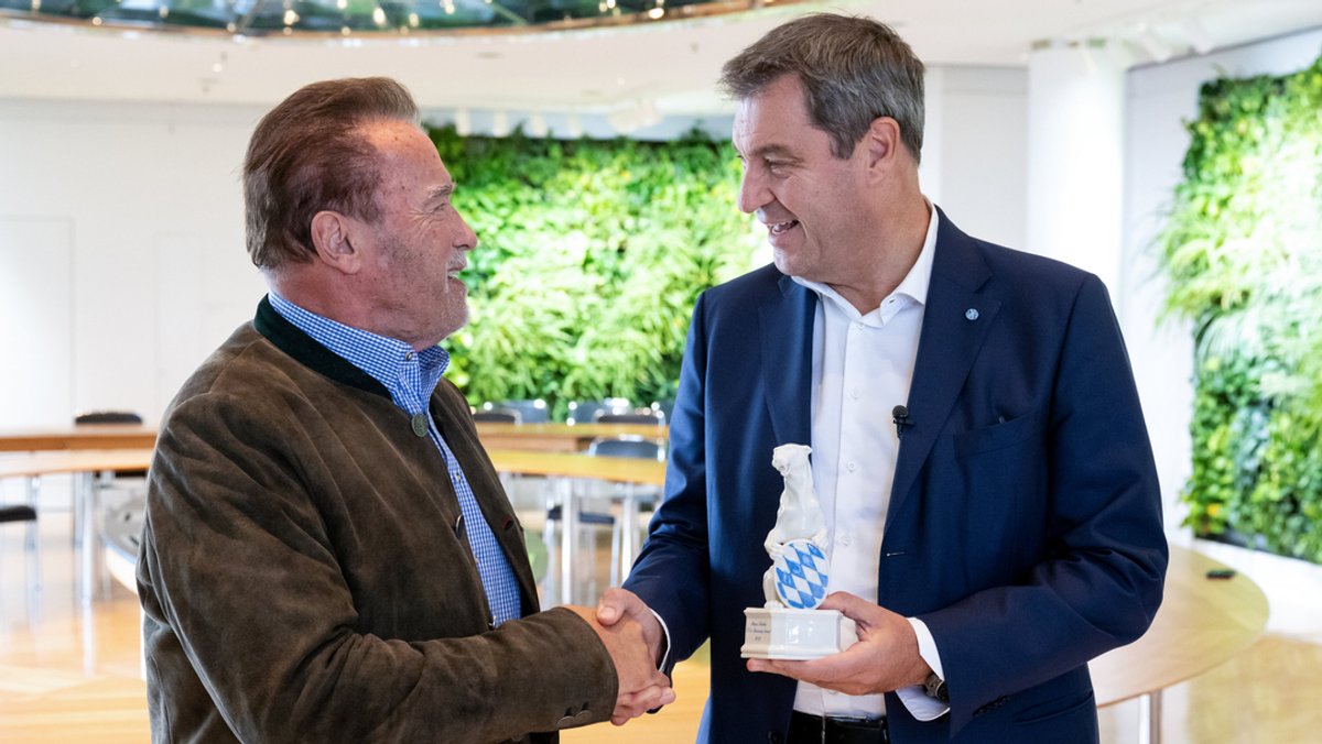 Ministerpräsident Söder (r., CSU) verleiht Schwarzenegger, Schauspieler und ehemaliger Gouverneur von Kalifornien, den "Blauen Panther".