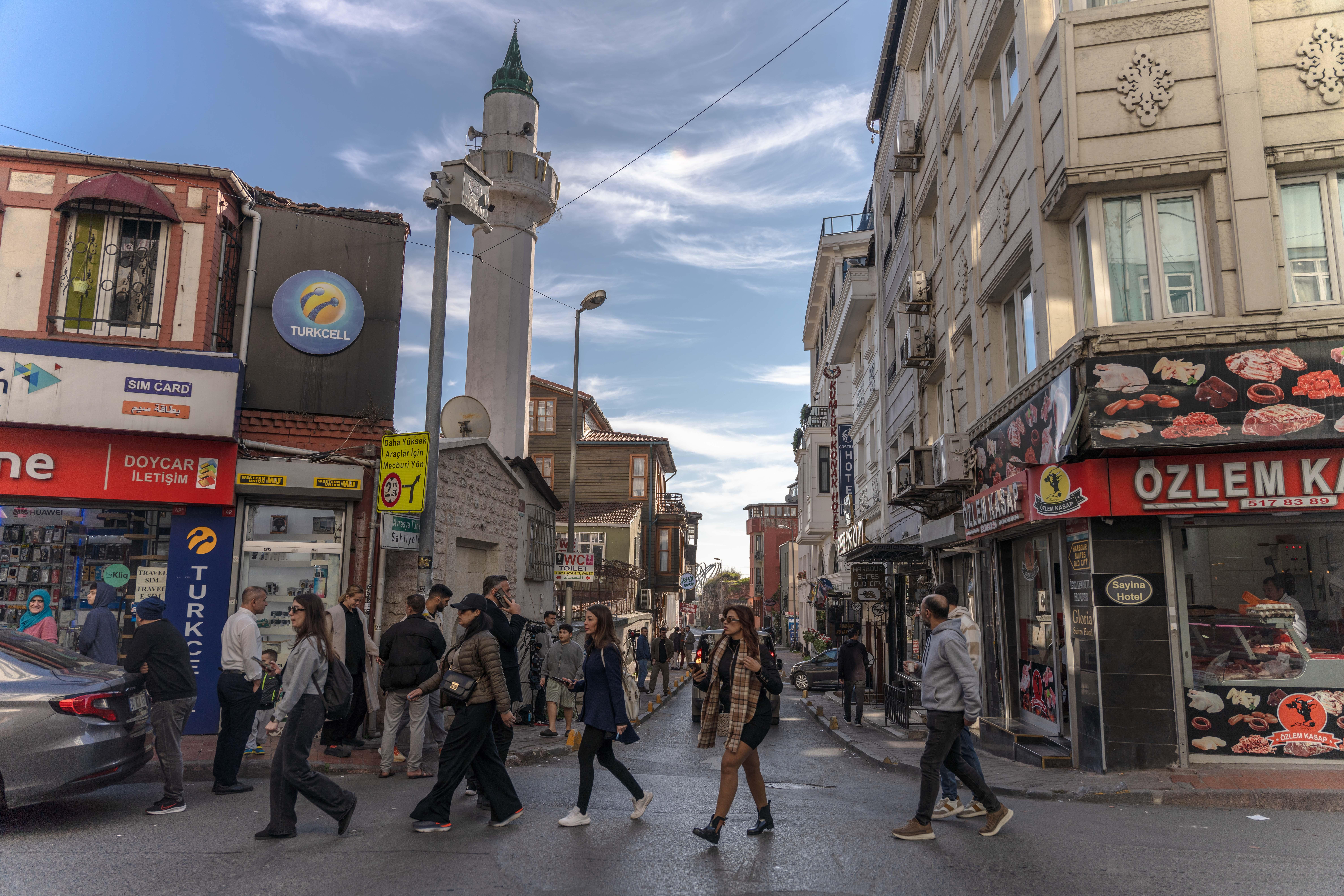 Menschen gehen im Istanbuler Stadtteil Fatih eine Straße entlang.