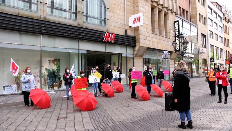 Demonstration mit roten Regenschirmen vor einer Filiale von H&M in Nürnberg