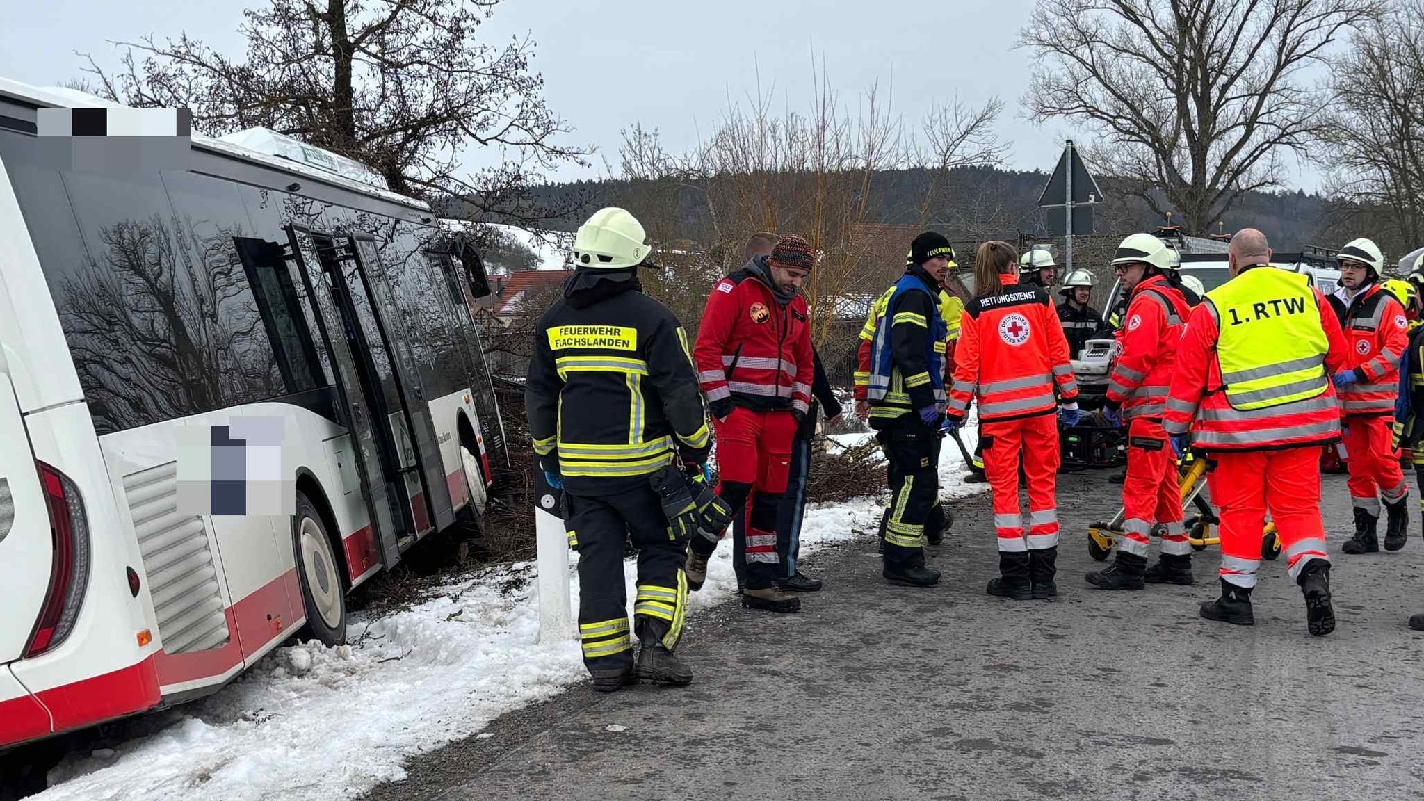 Einsatzkräfte von Feuerwehr und Rettungsdienst stehen neben einem verunfallten Bus. Dieser steht abseits der Straße im Schnee. | Bild: News5 / Kevin Weddig Einsatzkräfte von Feuerwehr und Rettungsdienst stehen neben einem verunfallten Bus. Dieser steht abseits der Straße im Schnee.