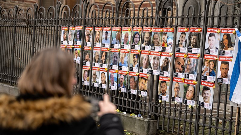 Symbolbild: Eine Frau fotografiert die Bilder der von Hamas entführten Geiseln am Zaun vor der Neuen Synagoge Berlin. | Bild: picture alliance/dpa | Fabian Sommer Symbolbild: Eine Frau fotografiert die Bilder der von Hamas entführten Geiseln am Zaun vor der Neuen Synagoge Berlin.
