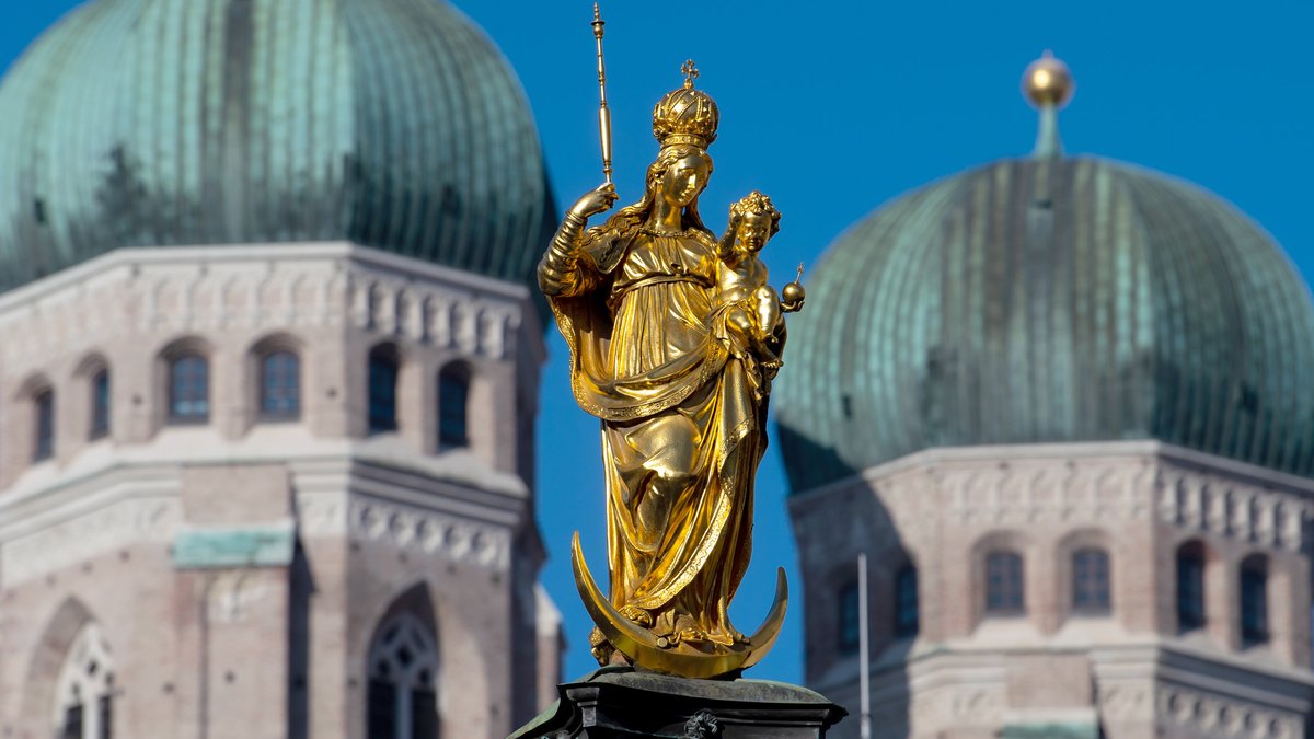 Die Mariensäule auf dem Marienplatz glänzt vor den Türmen der Frauenkirche.