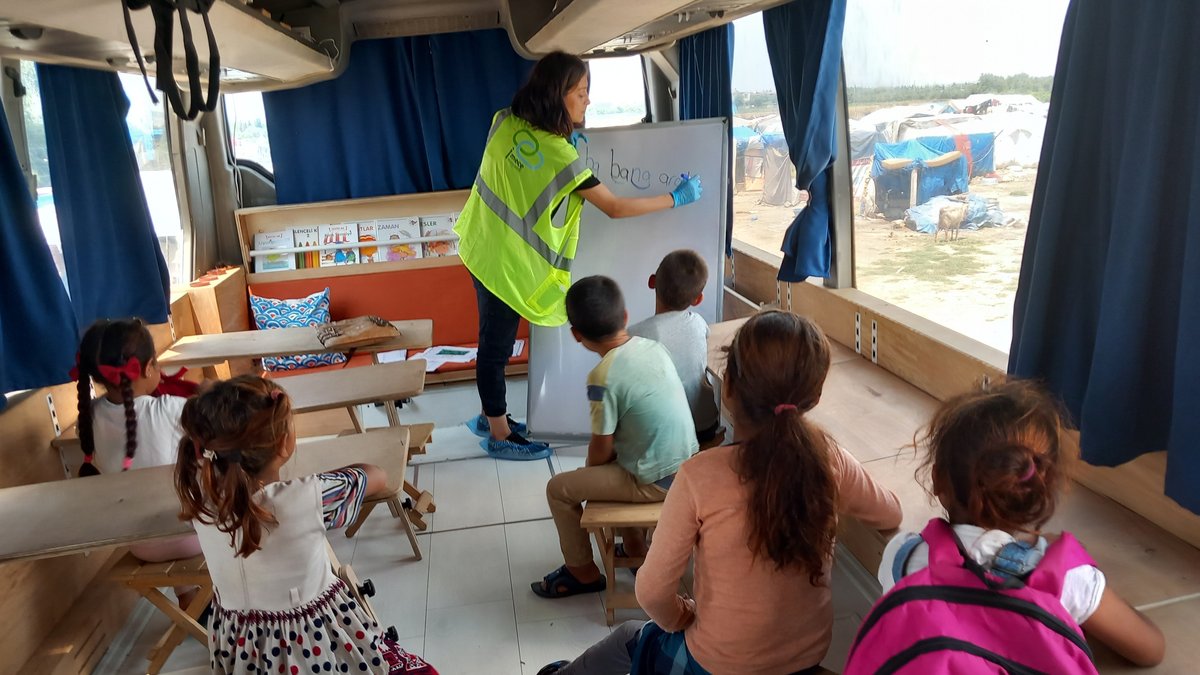 In einem umgebauten Bus sitzen Kinder für den Unterricht 