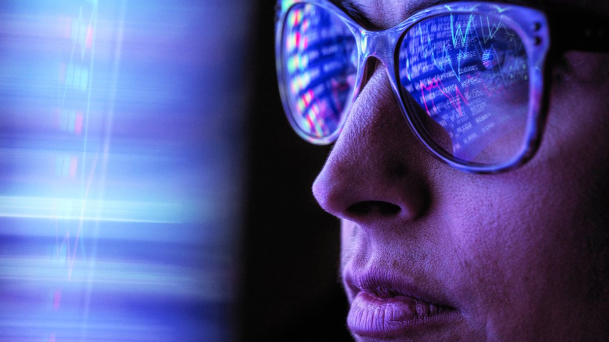 In einer Brille von einer Frau spiegelt sich der Computerbildschirm