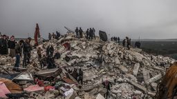Rettungskräfte und Zivilisten suchen nach Menschen in den Trümmern eines zerstörten Gebäudes.  | Bild:dpa-Bildfunk/Anas Alkharboutli