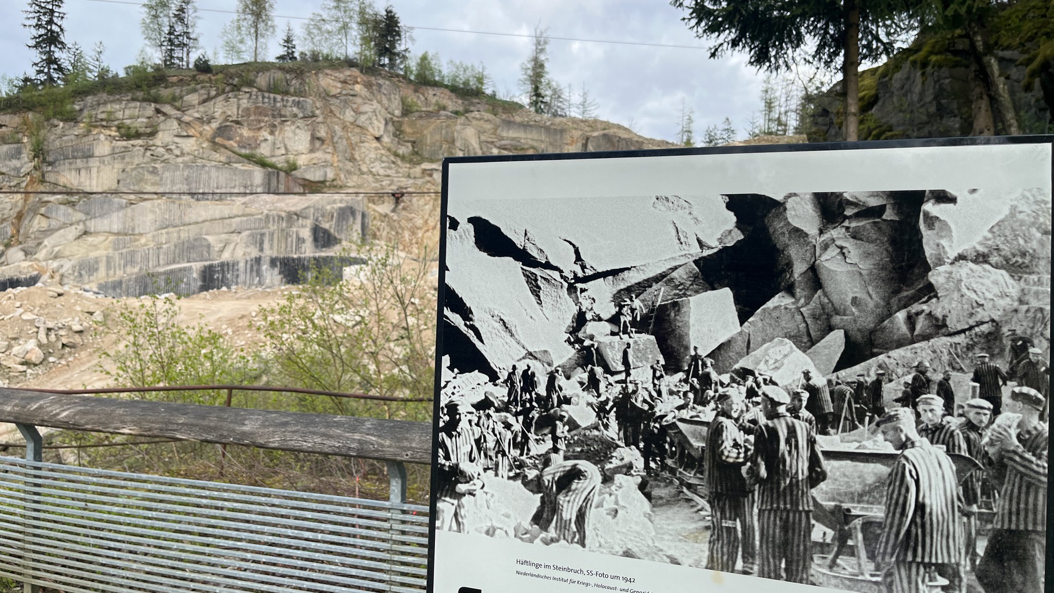 Der Granitsteinbruch. Im Vordergrund eine Dokumentationstafel.