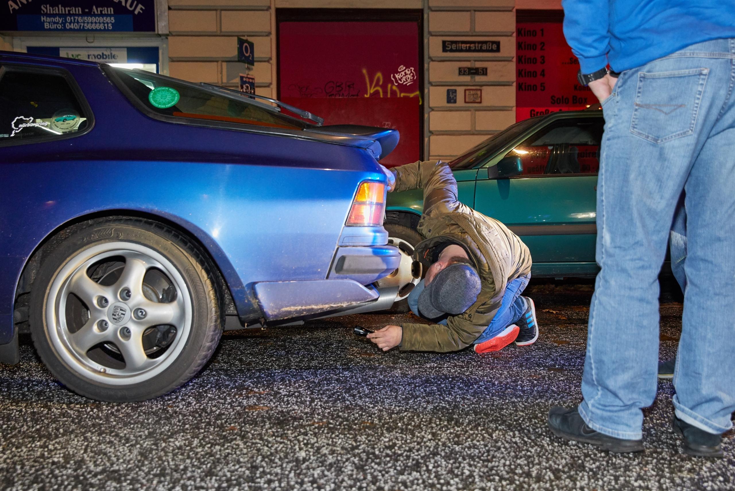 Ein Polizist der Kontrollgruppe "Autoposer" überprüft in Hamburg einen Porsche (Archivbild)
