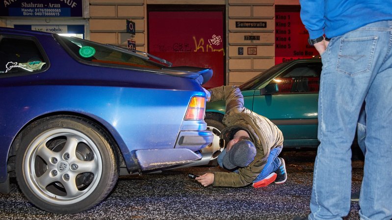 Ein Polizist der Kontrollgruppe "Autoposer" überprüft in Hamburg einen Porsche (Archivbild)
