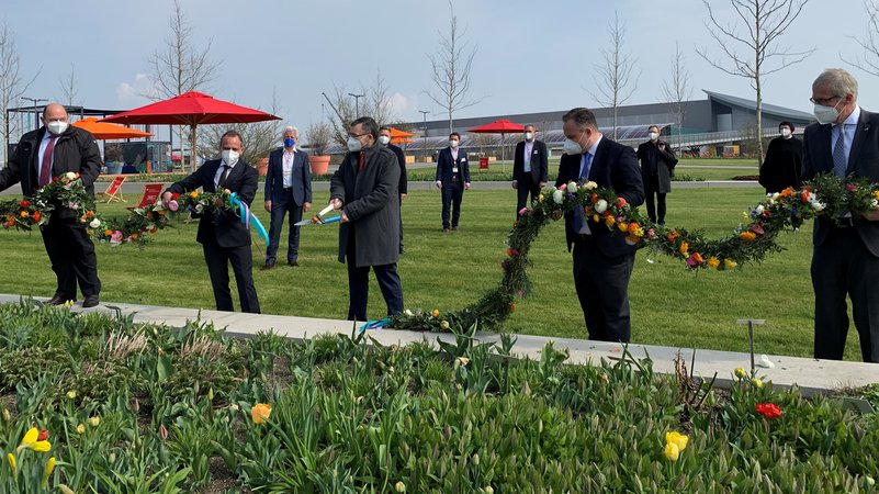Staatsminister Florian Herrmann durchschneidet die Blumengirlande.
